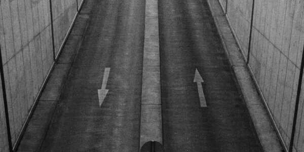 A picture of two different lanes of road with arrows in each direction